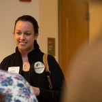 A woman smiles at those she is talking to